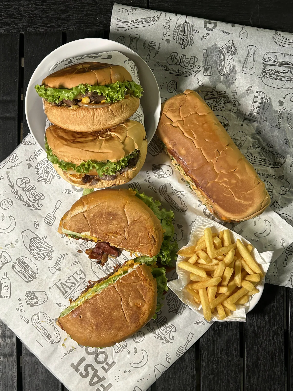 Lanches do Mastercheff dispostos sobre uma mesa com batatas fritas
